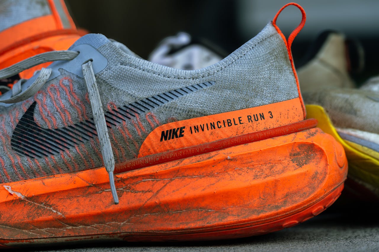hero-img-02 Close-up of worn Nike Invincible Run 3 shoes on concrete, showing wear and tear.